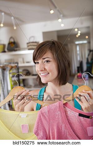 Stock Photography - Hispanic woman shopping in clothing store. Fotosearch