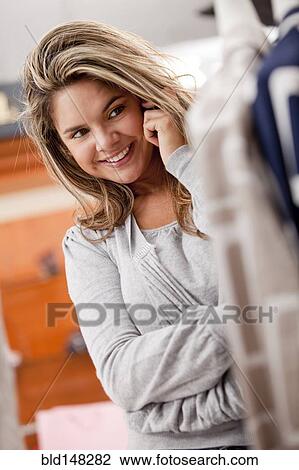 Stock Image - Hispanic woman talking on cell phone in store. Fotosearch
