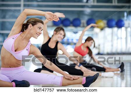 Stock Photo - Hispanic women exercising in health club. Fotosearch