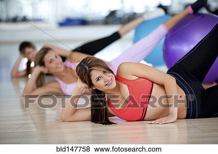 Stock Photo - Hispanic women exercising in health club. Fotosearch