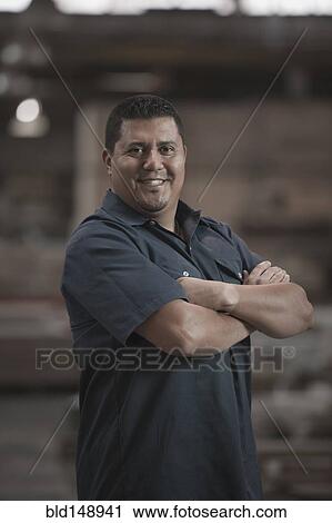 Hispanic worker standing in warehouse View Large Photo Image Stock Image - Hispanic worker standing in warehouse. Fotosearch