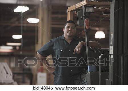 Hispanic worker standing in warehouse View Large Photo Image Stock Photography - Hispanic worker standing in warehouse. Fotosearch