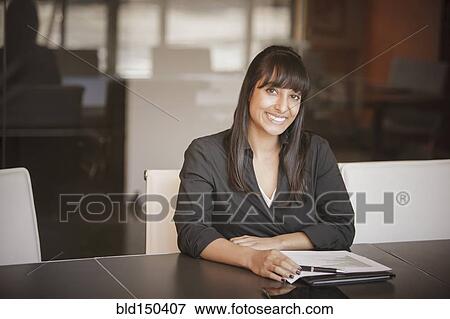 Indian businesswoman smiling at desk View Large Photo Image Stock Photo - Indian businesswoman smiling at desk. Fotosearch