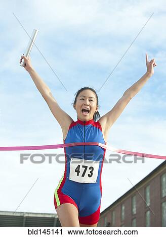 Stock Image - Japanese relay runner winning race. Fotosearch
