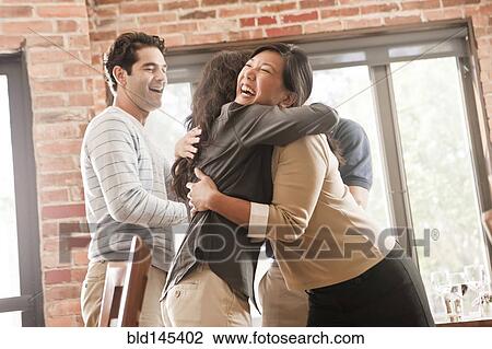 Stock Image - Laughing friends hugging. Fotosearch