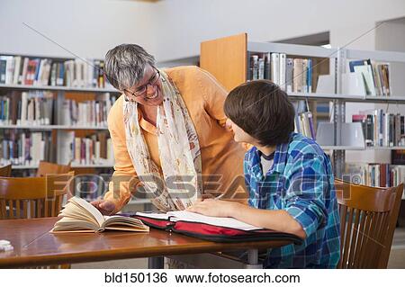 Stock Photograph - Librarian helping student in library. Fotosearch