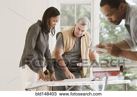 Man and woman looking at blueprints together View Large Photo Image Stock Image - Man and woman looking at blueprints together. Fotosearch