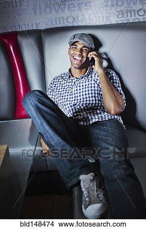 Man talking on cell phone in nightclub booth View Large Photo Image Picture - Man talking on cell phone in nightclub booth. Fotosearch