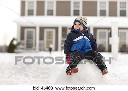 Mixed race boy sitting on large snowball View Large Photo Image Stock Image - Mixed race boy sitting on large snowball. Fotosearch