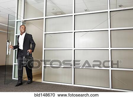 Mixed race businessman leaving modern office View Large Photo Image Stock Image - Mixed race businessman leaving modern office. Fotosearch