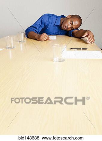 Mixed race businessman sleeping on conference room table View Large Photo Image Stock Photo - Mixed race businessman sleeping on conference room table. Fotosearch
