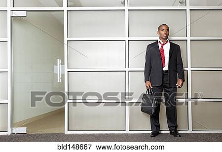 Stock Photo - Mixed race businessman standing in modern office. Fotosearch