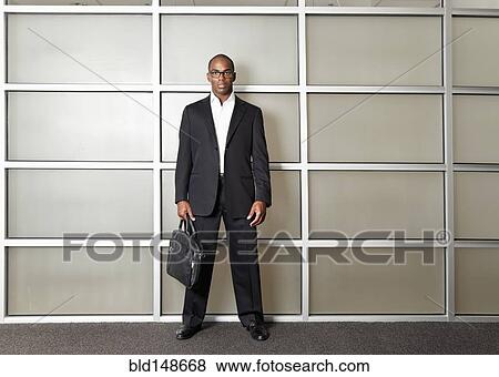 Stock Photo - Mixed race businessman standing in modern office. Fotosearch
