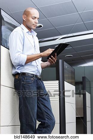 Mixed race businessman using digital tablet in office View Large Photo Image Stock Photo - Mixed race businessman using digital tablet in office. Fotosearch