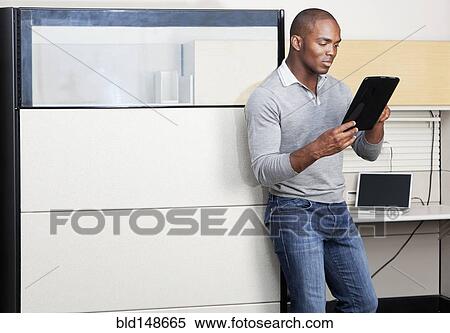 Mixed race businessman using digital tablet in office View Large Photo Image Stock Photography - Mixed race businessman using digital tablet in office. Fotosearch