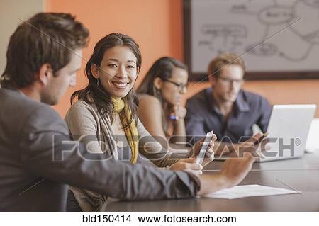 Picture - Mixed race businesswoman smiling in meeting. Fotosearch