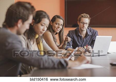 Stock Photograph - Mixed race businesswoman smiling in meeting. Fotosearch
