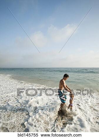 Mixed race father and daughter playing in ocean together View Large Photo Image Stock Photography - Mixed race father and daughter playing in ocean together. Fotosearch