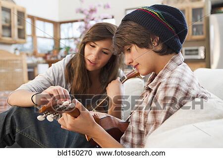 Mixed race friends playing ukulele View Large Photo Image Stock Image - Mixed race friends playing ukulele. Fotosearch