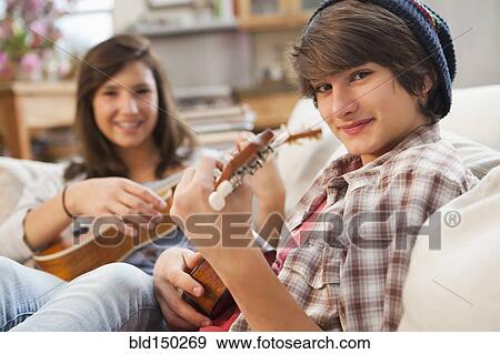 Stock Photo - Mixed race friends playing ukulele. Fotosearch