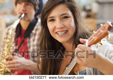 Stock Image - Mixed race girl playing guitar. Fotosearch