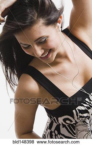 Mixed race woman listening to headphones and dancing View Large Photo Image Stock Photo - Mixed race woman listening to headphones and dancing. Fotosearch