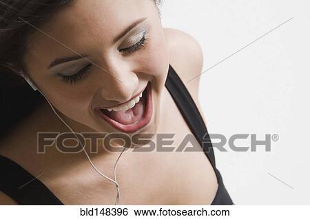 Mixed race woman listening to headphones and singing View Large Photo Image Stock Photograph - Mixed race woman listening to headphones and singing. Fotosearch