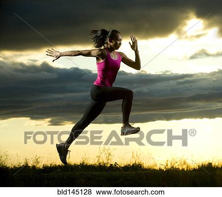 Mixed race woman running in field at night View Large Photo Image Stock Photo - Mixed race woman running in field at night. Fotosearch