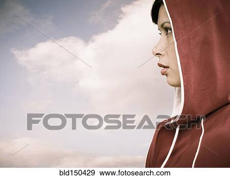 Stock Photo - Mixed race woman wearing hoodie outdoors. Fotosearch