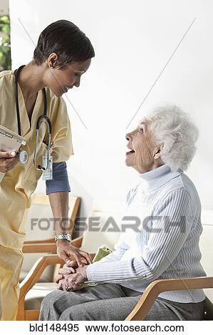 Stock Photography - Nurse talking to elderly woman. Fotosearch