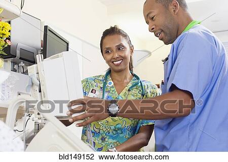 Stock Image - Nurses working together in hospital. Fotosearch