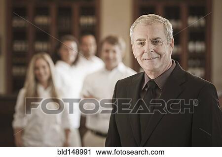 Stock Image - Owner and wait staff in restaurant. Fotosearch