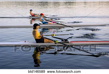 Stock Photo - People rowing sculling boats on river. Fotosearch