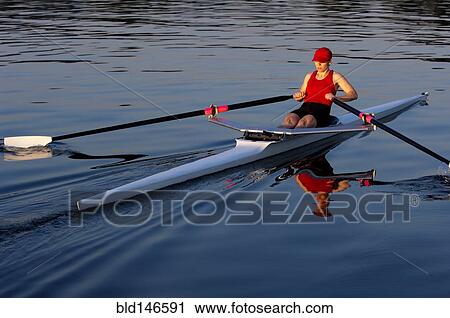 Stock Image - Person rowing sculling boat on river. Fotosearch