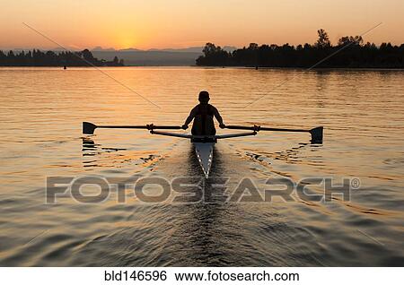 Stock Photograph - Person rowing sculling boat on river. Fotosearch