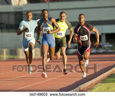 Stock Image - Relay racers running on track in race. Fotosearch