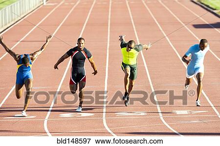 Stock Photo - Runners running across finish line on track in race. Fotosearch
