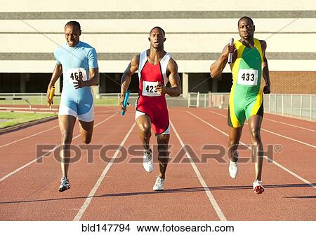 Picture - Runners running on track in relay race. Fotosearch