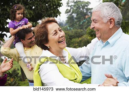 Stock Image - Senior Hispanic couple dancing outdoors. Fotosearch