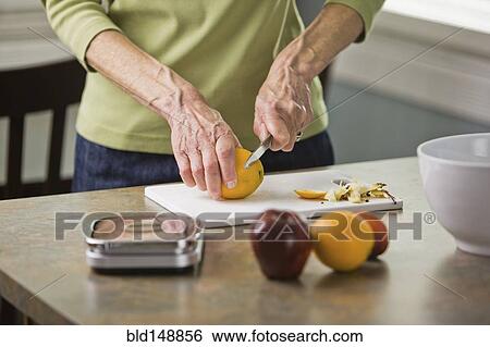 Senior woman cutting fruit View Large Photo Image Stock Photograph - Senior woman cutting fruit. Fotosearch