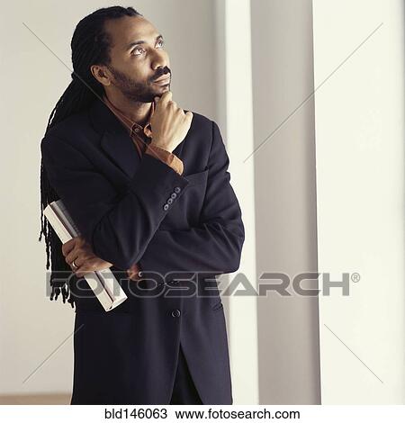 Stock Image - Serious African American businessman with hand on chin. Fotosearch