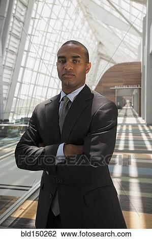 Serious Black businessman standing with arms crossed View Large Photo Image Stock Image - Serious Black businessman standing with arms crossed. Fotosearch