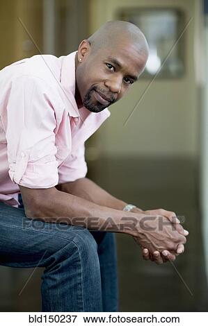 Stock Photo - Serious Black man with hands clasped. Fotosearch