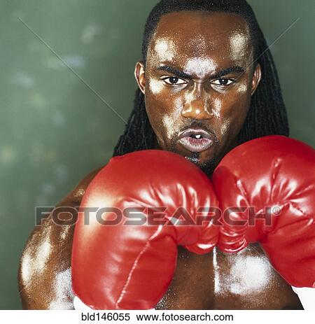 Stock Photography - Serious boxer holding gloves up. Fotosearch