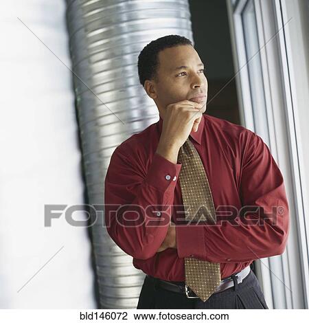 Serious businessman with hand on chin View Large Photo Image Stock Image - Serious businessman with hand on chin. Fotosearch