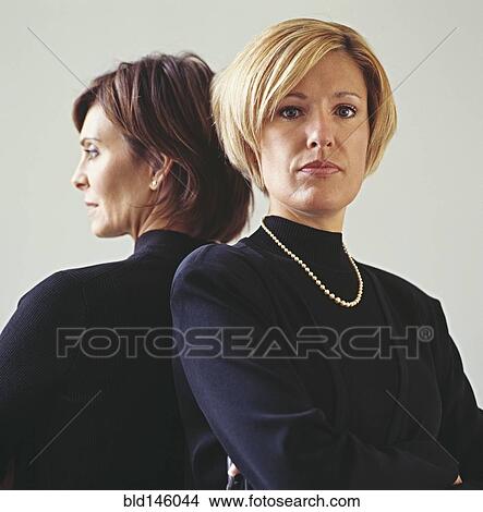 Picture - Serious businesswomen back to back. Fotosearch