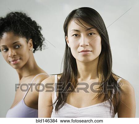 Picture - Serious Chinese woman with friend in background. Fotosearch