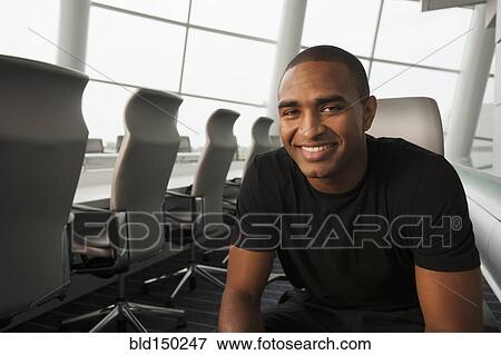Smiling Black businessman sitting in conference room View Large Photo Image Stock Photo - Smiling Black businessman sitting in conference room. Fotosearch
