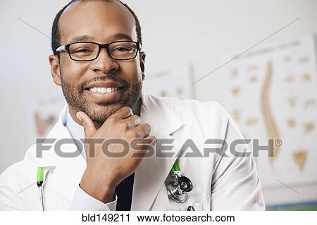 Smiling Black doctor in doctor's office View Large Photo Image Stock Image - Smiling Black doctor in doctor's office. Fotosearch
