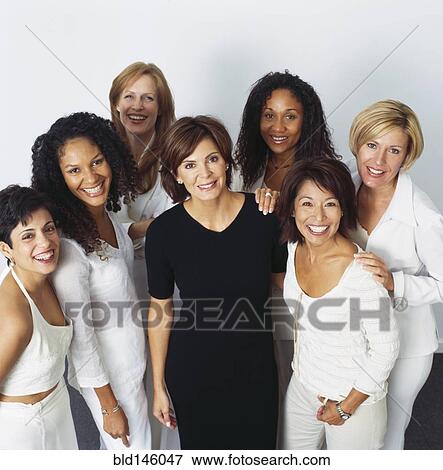 Smiling businesswomen dressed in white one in black View Large Photo Image Stock Photo - Smiling businesswomen dressed in white one in black. Fotosearch